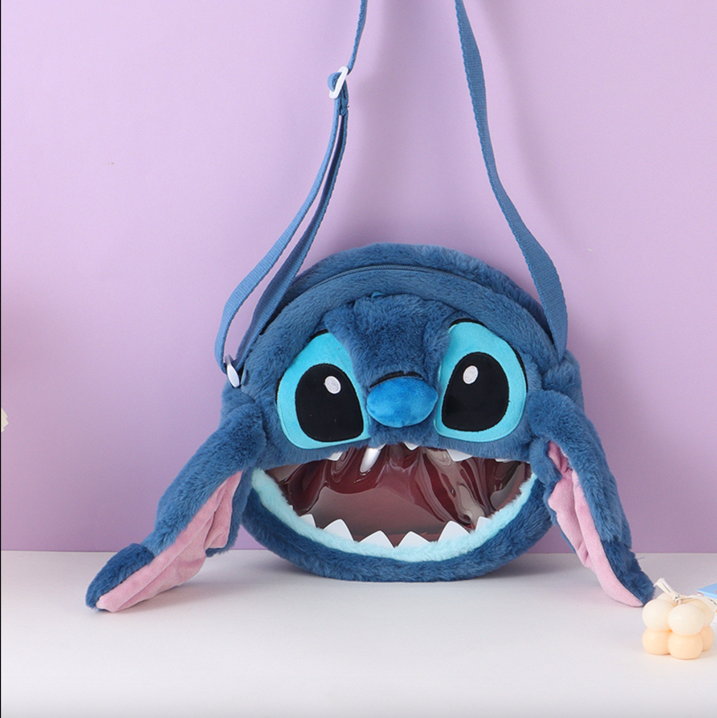 Disney Stitch hangs his ears to show off his baby and crosses his bag diagonally