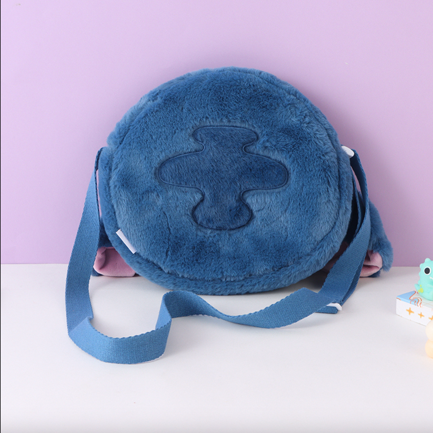 Disney Stitch hangs his ears to show off his baby and crosses his bag diagonally
