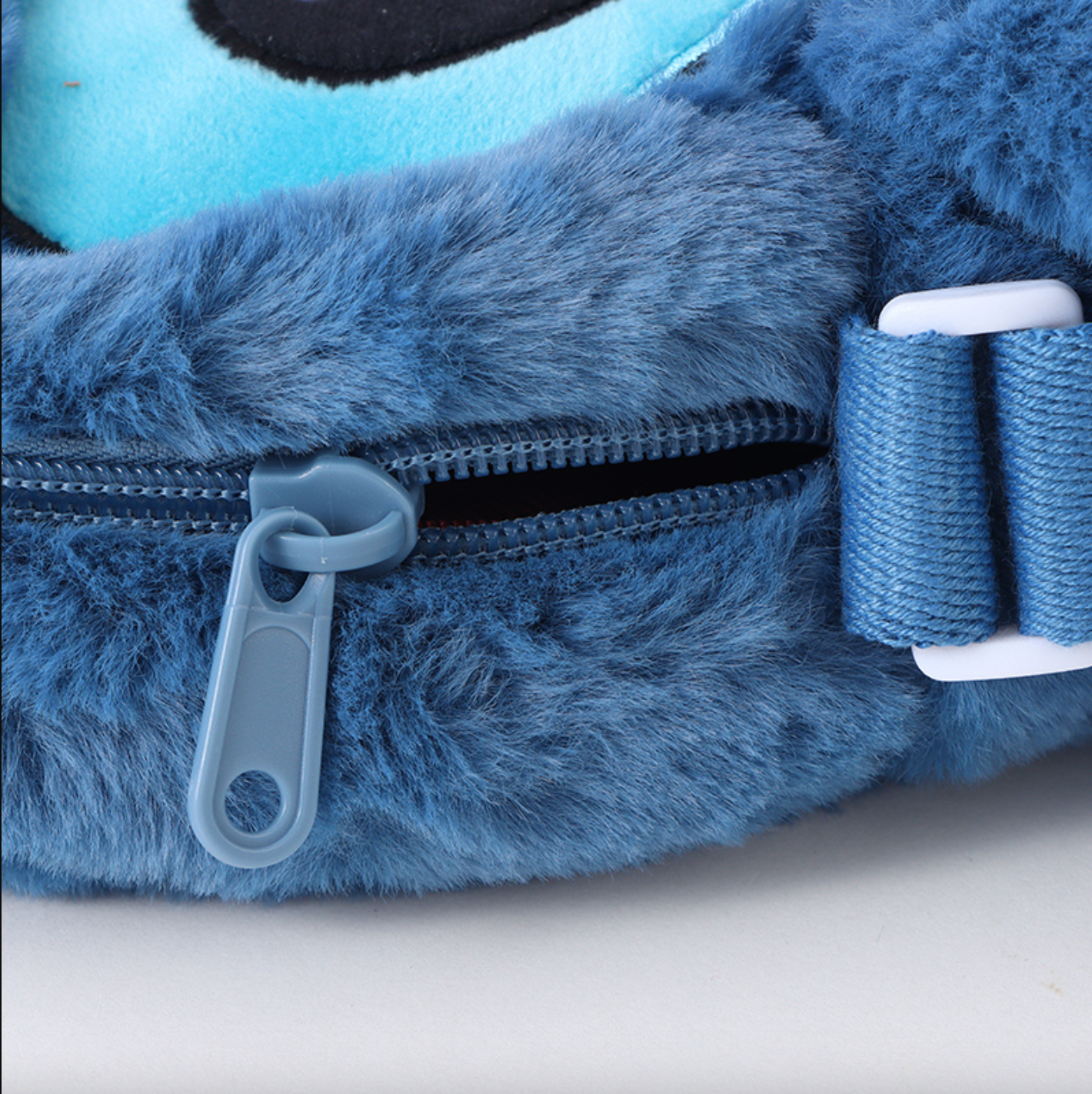 Disney Stitch hangs his ears to show off his baby and crosses his bag diagonally